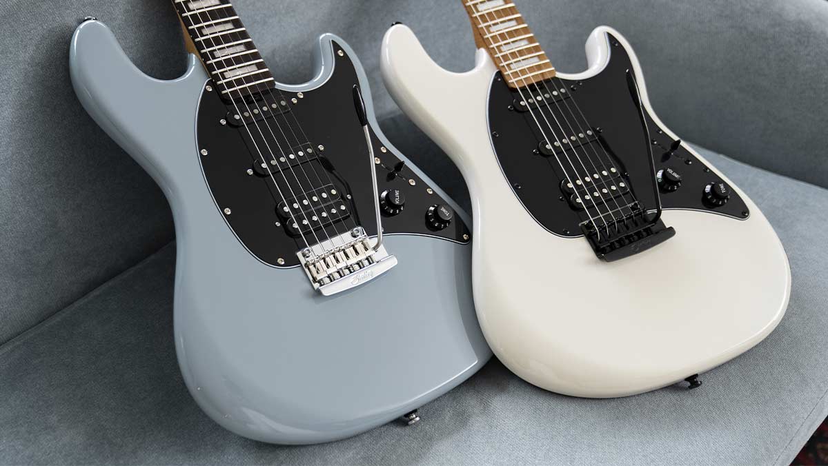 Two electric guitars on a grey sofa