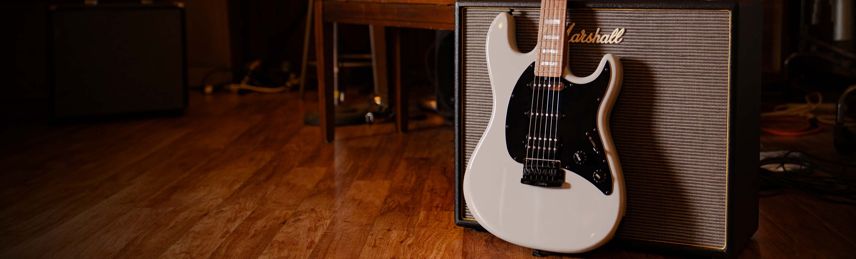 Two electric guitars in front of a media console